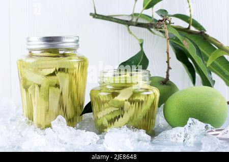 Hausgemachte Manisan oder Asinan Mangga ist kandierte junge Mango Pickles, dünn geschnitten Mix mit Wasser und Zucker Stockfoto