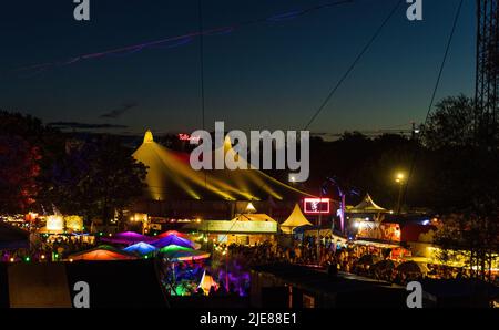 MÜNCHEN, DEUTSCHLAND - 26. JUNI 2022: Das berühmte Sommer-Tollwood Festival bei Nacht. Nach einer zweijährigen Pause aufgrund der globalen Pandemie ist es wieder da Stockfoto