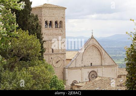 Die Kathedrale von San Rufino, Details der Fassade und der Turmglocke, mit der Ebene von Assisi im Hintergrund, Assisi, Italien. Es war wichtig Stockfoto