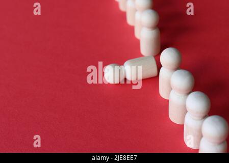 Holzpuppe fällt aus der Reihe. Moralische und körperliche Erschöpfung, Stress, Burnout bei der Arbeit Konzept. Stockfoto