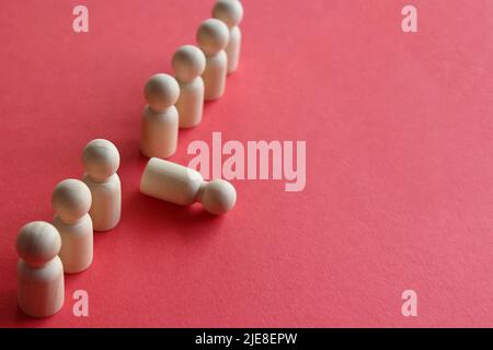 Holzpuppe fällt aus der Reihe. Moralische und körperliche Erschöpfung, Stress, Burnout bei der Arbeit Konzept. Stockfoto