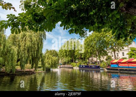 Farbenfrohe, typische Schmalbordboote, die entlang des Little Venice Basin, auf dem Regent Canal in Rembrant Gardens, um Browning's Island antäuten. Stockfoto