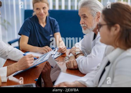 Erfolgreiche Ärzte diskutieren während der Konferenz über die Diagnose Stockfoto