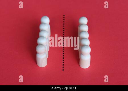 Die Menschen teilen sich in zwei Gruppen auf. Gemeinschafts-Zwietracht und Konflikt, Zerfall, unterschiedliche Meinungsbildung Stockfoto