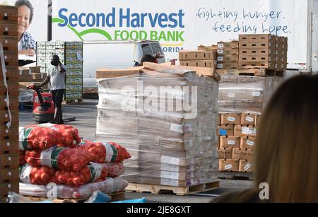 Orlando, Usa. 25.. Juni 2022. Bei einer Lebensmittelverteilungsveranstaltung für Bedürftige, die von der Second Harvest Food Bank of Central Florida und Orange County in der St. John Vianney Church in Orlando, Florida, gesponsert wird, werden Paletten mit Lebensmitteln von einem Lastwagen entladen. Hohe Lebensmittel- und Gaspreise drücken die arbeitenden Familien unter Druck und schicken einige zum ersten Mal in Lebensmittelvorratskammern, aber die Anbieter kämpfen mit den Inflationskosten, da die Nachfrage steigt. Kredit: SOPA Images Limited/Alamy Live Nachrichten Stockfoto