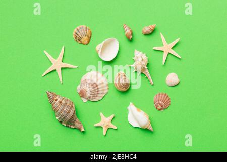 Summer Time Concept flache Lay-Komposition mit schönen Seesternen und Muscheln auf farbigem Tisch, Draufsicht. Stockfoto