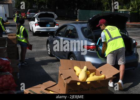 Orlando, Usa. 25.. Juni 2022. Freiwillige laden Lebensmittelsäcke in Autos bei einer Lebensmittelverteilungsveranstaltung für Bedürftige, die von der Second Harvest Food Bank of Central Florida und Orange County in der St. John Vianney Church in Orlando, Florida, gesponsert wird. Hohe Lebensmittel- und Gaspreise drücken die arbeitenden Familien unter Druck und schicken einige zum ersten Mal in Lebensmittelvorratskammern, aber die Anbieter kämpfen mit den Inflationskosten, da die Nachfrage steigt. (Foto von Paul Hennessy/SOPA Images/Sipa USA) Quelle: SIPA USA/Alamy Live News Stockfoto