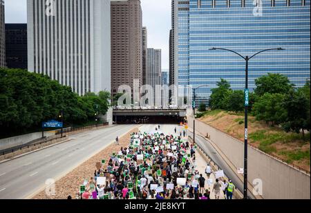 Chicago, USA. 25.. Juni 2022. Demonstranten marschieren am 25. Juni 2022 in der Innenstadt von Chicago, den Vereinigten Staaten, vorbei. Als der Oberste Gerichtshof der USA Roe v. Wade, eine bahnbrechende Entscheidung aus dem Jahr 1973, die ein verfassungsmäßiges Recht auf Abtreibung begründete, umkippte, überflutete eine Welle von Protesten und Empörung das Land. Kredit: Vincent D. Johnson/Xinhua/Alamy Live Nachrichten Stockfoto