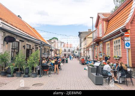 Parnu Altstadt Straße mit traditionellen Häusern und Menschen sitzen an den Tischen von Cafés und Restaurants Stockfoto