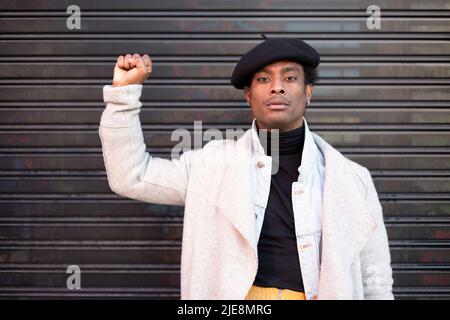 Afroamerikanischer junger erwachsener Mann mit erhobener Faust aus Protest gegen Gewalt mit schwarzen Menschen. Black Lives Matter Konzept. Stoppen Sie Rassismus. Stockfoto