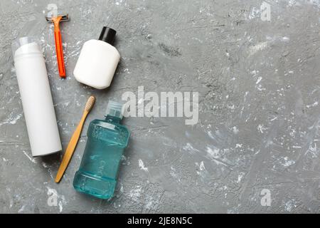 Zusammensetzung mit Badekosmetik auf dem Tisch. Rasiermesser, Zahnpasta, Seife, Gel, Zahnbürste, Mundspülung und anderes verschiedenes Zubehör. Kosmetik für die Gesundheit der Haut Stockfoto