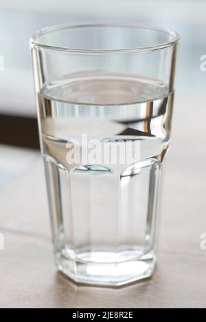 Ein Glas Wasser auf dem Tisch aus der Nähe Stockfoto