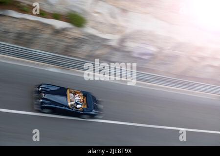 Die Formel-1-Rennstrecke in Monaco für den historischen Grand Prix 2022 wird mit einem Jaguar in die Sonne gefahren. Stockfoto