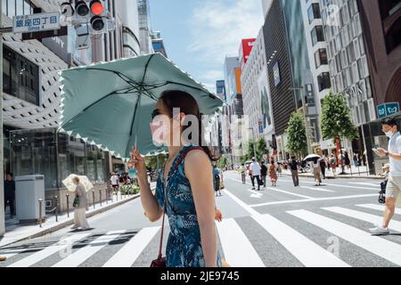 Tokio, Japan. 26.. Juni 2022. Menschen gehen auf einer Straße, während die Hitzewelle Tokio, Japan, trifft, 26. Juni 2022. Quelle: Zhang Xiaoyu/Xinhua/Alamy Live News Stockfoto