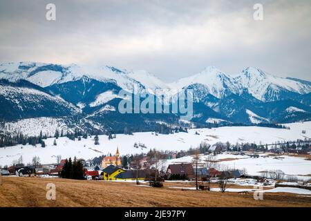 Das markante Dorf Zdiar mit einem Bergpanorama im Hintergrund im Winter. Nationalpark Hohe Tatra, Slowakei, Europa. Stockfoto