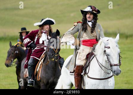 Eine Person, die die Rolle von König Charles II. Spielt, spricht während eines Pageants aus der Restaurationszeit während des Chalke Valley History Festivals in Broad Chalke, in der Nähe von Salisbury, Wiltshire, mit der Krone. Bilddatum: Sonntag, 26. Juni 2022. Stockfoto