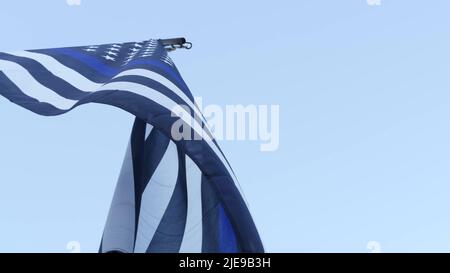 Schwarz-weiße amerikanische monochrome Flagge mit blauem Streifen oder Linie, Polizeiunterstützung. Solides, sternenbespanntes Banner, das in der Windbrise winkt. Stockfoto