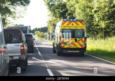 Krankenwagen mit blinkenden blauen Lichtern auf der Straße A66 Überhollinie des stationären Verkehrs, um den Verkehrsunfall zu erreichen, England, Großbritannien Stockfoto