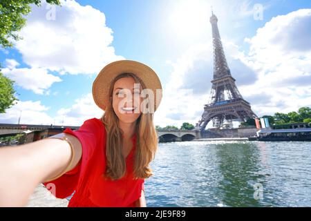 Junge Touristenfrau macht Selfie-Foto mit Eiffelturm auf dem Hintergrund an sonnigen Tagen in Paris, Frankreich Stockfoto