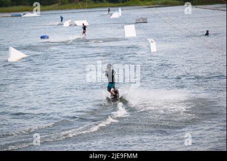 Norderstedt, Deutschland. 26.. Juni 2022. Mehrere Wasserskifahrer sind auf dem Stadtpark See. Quelle: Jonas Walzberg/dpa/Alamy Live News Stockfoto