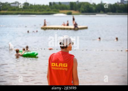 Norderstedt, Deutschland. 26.. Juni 2022. Ein Mitglied der DLRG steht im lido am Ufer des Stadtparksee und beobachtet Badegäste. Quelle: Jonas Walzberg/dpa/Alamy Live News Stockfoto