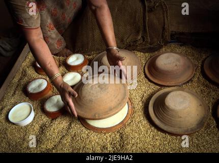 Bhaktapur, Bagmati, Nepal. 26.. Juni 2022. Yamuna Hada Pakwan deckt die mit Milch gefüllten irdenen Behälter zur Zubereitung des traditionellen Joghurts ''Juju Dhau'' am 26. Juni 2022 in Bhaktapur, Nepal. ''Juju Dhau'', der König des Joghurts (in Newari-Sprache) ist der berühmte nepalesische traditionelle zubereitete Joghurt, der am National Paddy Day, einem Tag zum Anpflanzen von Reiskulturen, besonders mit geschlagenem Reis verzehrt wird. (Bild: © Sunil Sharma/ZUMA Press Wire) Stockfoto