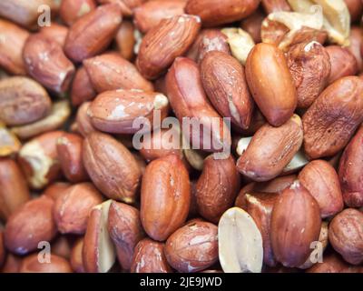 Geröstete, ungeschälte Erdnüsse, Makro. Nahaufnahme des Erdnüsse-Hintergrunds Stockfoto