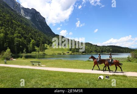 Elmau, Deutschland. 26.. Juni 2022. Polizeibeamte des Pferdegeschwaders patrouillieren vor einer gemeinsamen Nordic-Walking-Tour durch die Partner der G7 Teilnehmer am Ferchensee. Deutschland wird vom 26. Bis 28. Juni G7 2022 Gastgeber des Gipfels der wirtschaftlich starken Demokratien sein. Quelle: Karl-Josef Hildenbrand/dpa/Alamy Live News Stockfoto