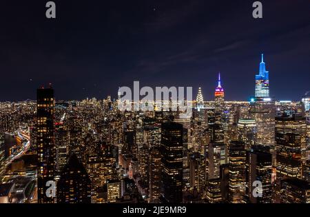 Beleuchtete Fenster in moderner Stadtentwicklung. Panoramablick auf die Wolkenkratzer in der Innenstadt bei Nacht. Manhattan, New York City, USA Stockfoto