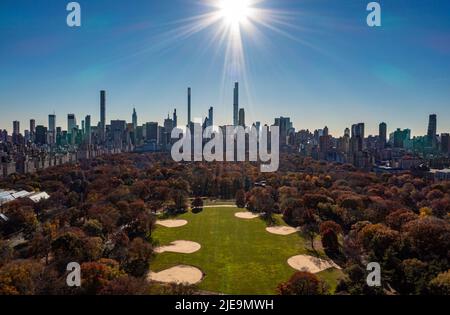 Weite Panoramaaufnahme des Herbstes im Central Park und den umliegenden Hochhäusern vor Sonnenschein. Manhattan, New York City, USA Stockfoto