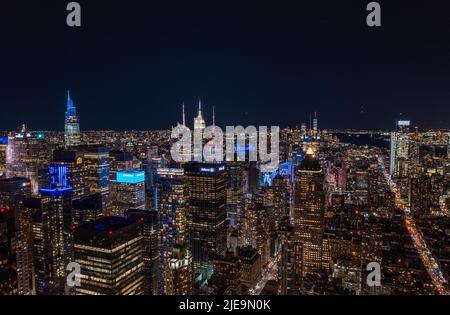 Luftpanorama der Metropole bei Nacht. Farbenfrohe Neonlichter an Hochhäusern in Stadtbezirks. Manhattan, New York City, USA Stockfoto