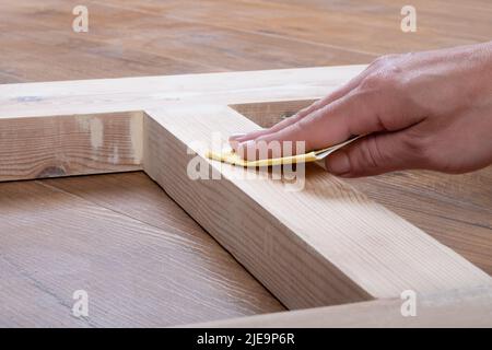 Holzarbeiter von Hand schleifen Holztüren für Lackierung oder Fleck. Stockfoto