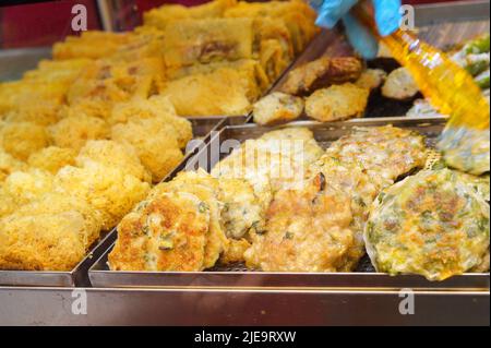 Street Food in Hongkong. Gebratene Gemüse- und Fleischkuchen Stockfoto
