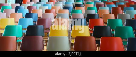 Nahansicht eines leeren Auditoriums mit farbenfrohen Sitzplätzen. Stockfoto