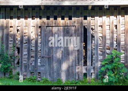 Alte Feuerholzscheune mit alten Holztüren Stockfoto