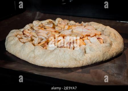 Gebackene hausgemachte Galette, offener Kuchen mit Äpfeln im Elektroofen Stockfoto