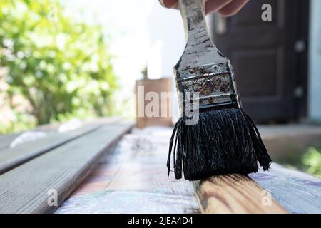 Die Lackierung der hölzernen Möbel für die Türen, färben die hölzerne Planke mit der Bürste. Stockfoto