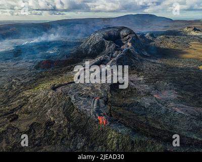 Draufsicht auf den aktiven Krater auf der isländischen Halbinsel Reykjanes. Landschaft mit abgekühltem Lavastrom um den Krater mit einzelnen Dampfsäulen. Grün, blac Stockfoto