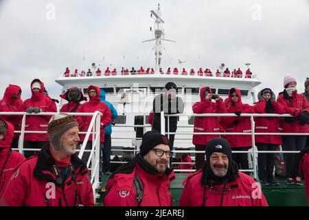 Touristen auf dem Deck der G Adventures Schiffsexpedition, als sie den Lemaire Channel Antarctica begibt Stockfoto