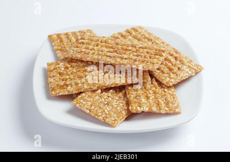 Honig Sesamstangen in Teller auf weißem Hintergrund Nahaufnahme Stockfoto