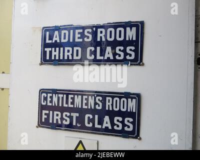 Alte Schilder von alten Bahnhöfen, die weibliche Ungleichheit vermitteln: „Ladies“ Room Third Class“; „Gentlemen's Room First Class“ Stockfoto