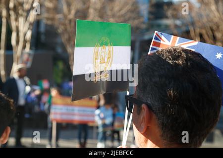 Brisbane, Australien. 26.. Juni 2022. Ein Protestler hält während der Kundgebung auf dem King George Square Flaggen. Mitglieder der tadschikischen Gemeinschaft von Queensland organisierten eine Kundgebung auf dem King George Square in Brisbane, um die von den Taliban in Afghanistan verfolgten Menschen zu unterstützen. Zu den Themen, die von Rednern angesprochen wurden, gehörten der Zerfall der Frauenrechte im Land seit der vollständigen Kontrolle der Taliban im August 2021, die vielen Opfer von Gewalt, darunter das tadschikische Volk, und was die australische Regierung tun kann, um Flüchtlinge besser zu unterstützen. Kredit: SOPA Images Limited/Alamy Live Nachrichten Stockfoto