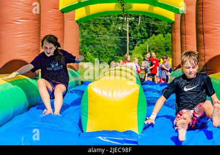 Kinder spielen am 27. Juli 2012 auf einer aufblasbaren Wasserrutsche in Columbus, Mississippi. Stockfoto