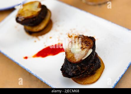 Spanischer Timbale aus Morcilla mit karamellisierten Birnen und Käse Stockfoto