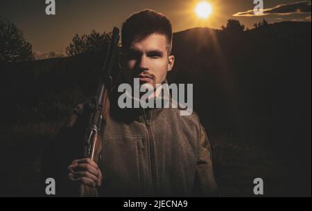 Hunting Gear - Jagdzubehör und Ausrüstung. Jäger mit Schrotflinte auf der Jagd. Illegaler Jagdwilder im Wald. Nahaufnahme Porträt von Hamdome Stockfoto