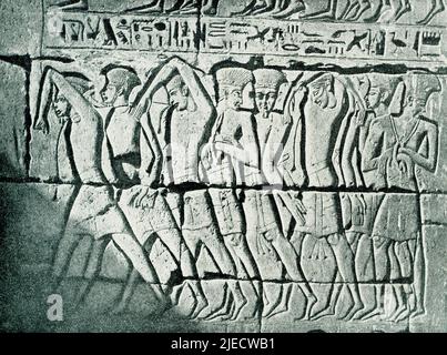 Dieses Bild aus dem Jahr 1908 zeigt repräsentative asiatische Küstenmenschen (Philister) als Gefangene des Königs Ramses III. Ein Wandrelief in einem Tempel bei Medinet Habu (altes Theben). Medinet Habu ist der Leichentempel der ägyptischen 20. Dynastie pharao Ramses III (c. 1150 v. Chr.) am Westufer des alten Theben (heutiges Luxor). Stockfoto