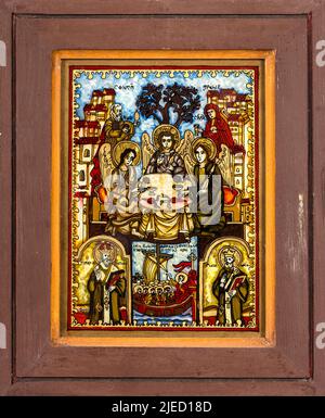 Ikone auf Rückglas im naiven orthodoxen Stil Osteuropas, die die Heilige Dreifaltigkeit darstellt. Stockfoto