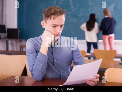 Junge nachdenkliche Kerl Vorbereitung für die Prüfung im Klassenzimmer Stockfoto
