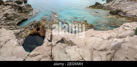 Ventimiglia, Ligurien, Provinz Imperia, Italien .Wild Balzi Rossi Strand, Grenze zu Frankreich mit Blick auf Menton. Stockfoto