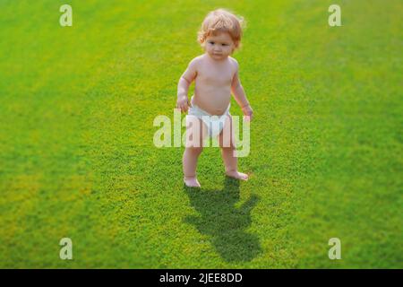Warmes Frühlingskind mit Windel im Park. Stockfoto